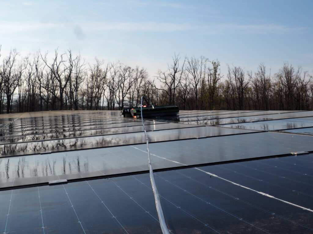 Robot de nettoyage NRI OPTI+ en action sur une centrale solaire au sol