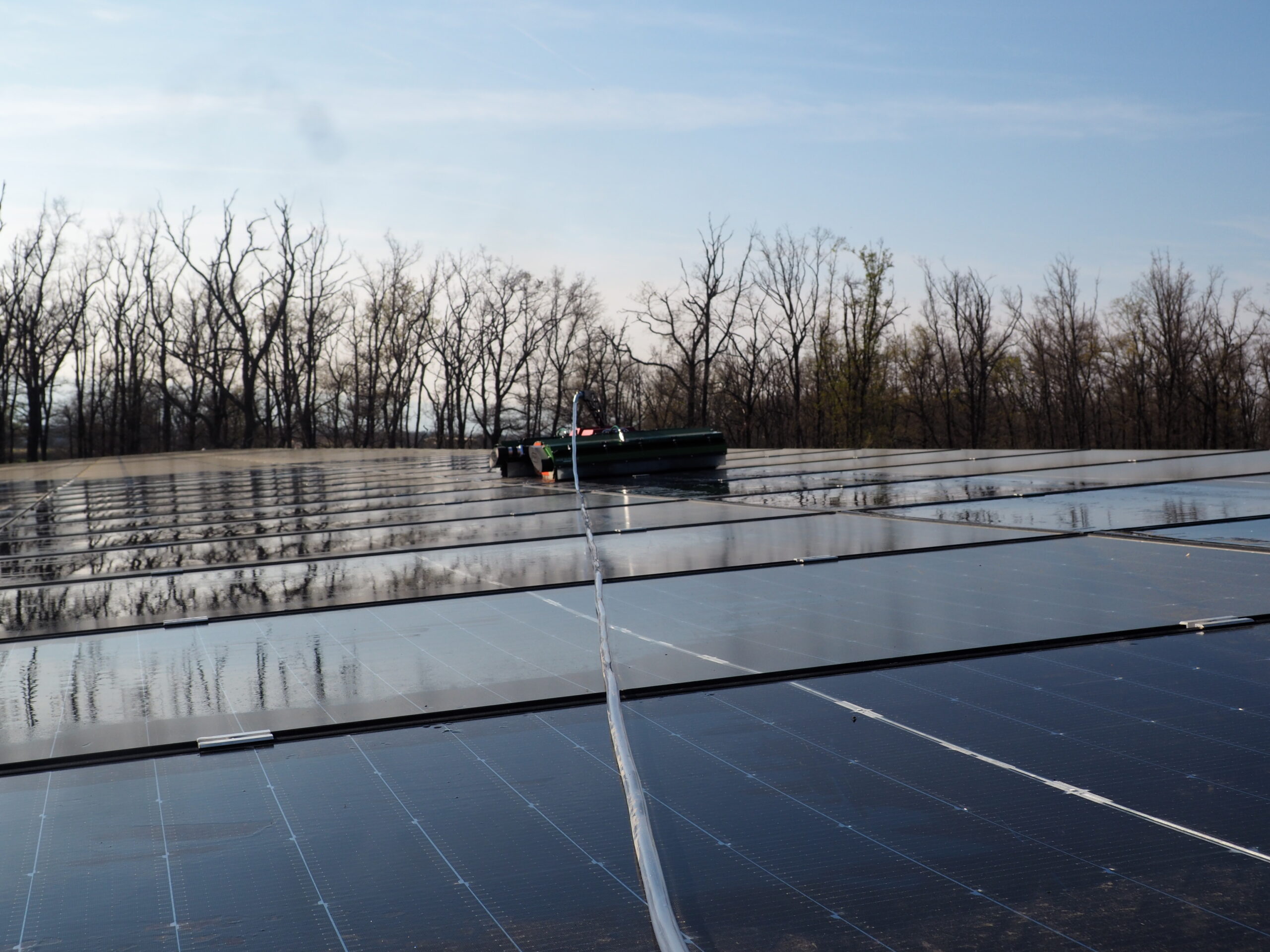 Robot de nettoyage NRI OPTI+ en action sur une centrale solaire au sol